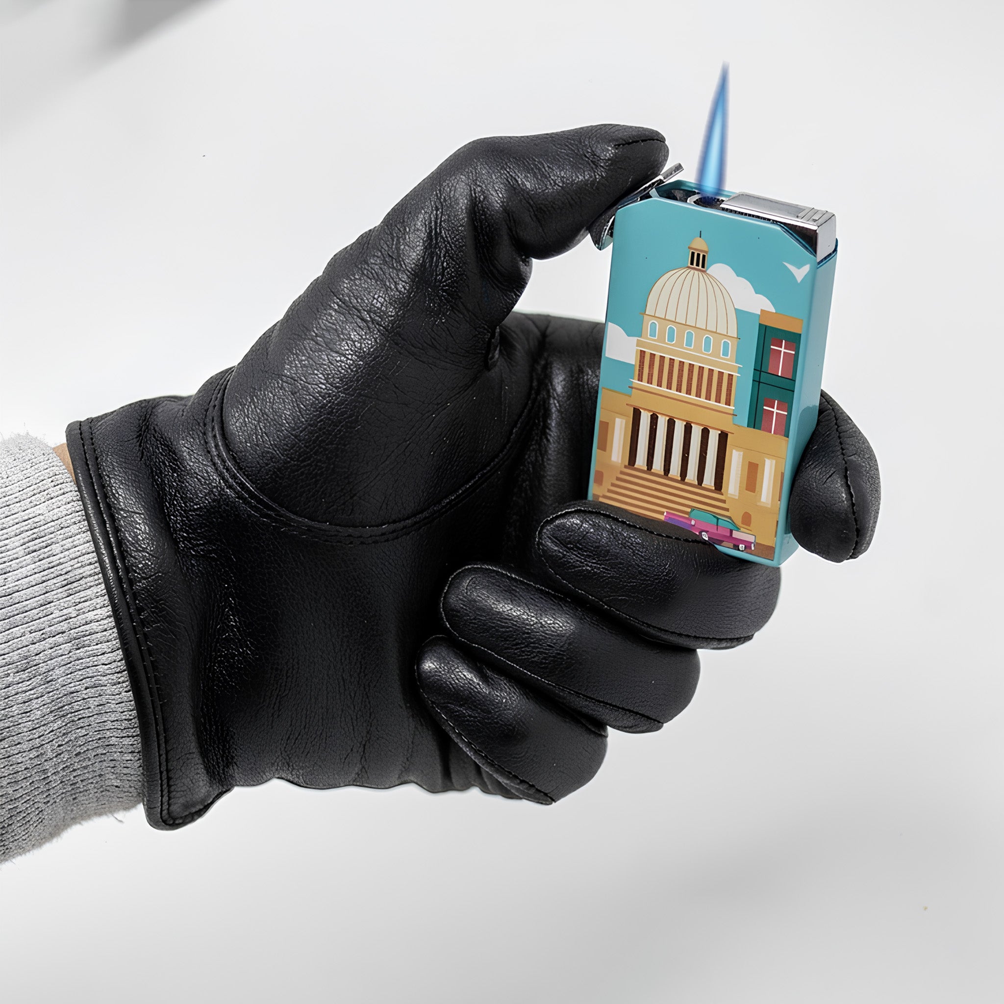 Hand wearing a black glove holding a small, colorful lighter with a design on a white background
