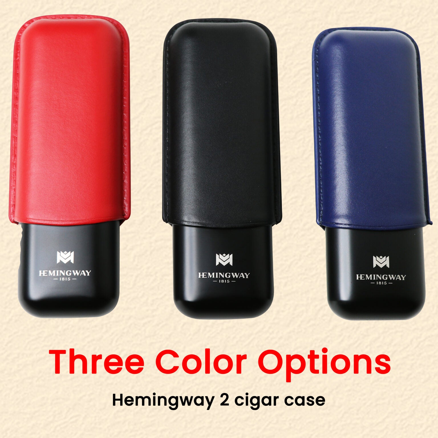 Three Hemingway 2 cigar cases in red, black, and blue on a beige background.