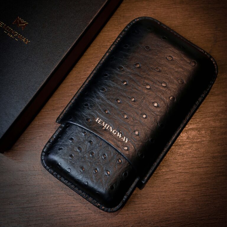 Black leather case with 'Hemingway' branding on a wooden surface