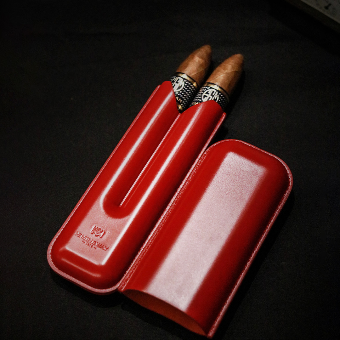Hemingway Red leather cigar case with two cigars on a black background